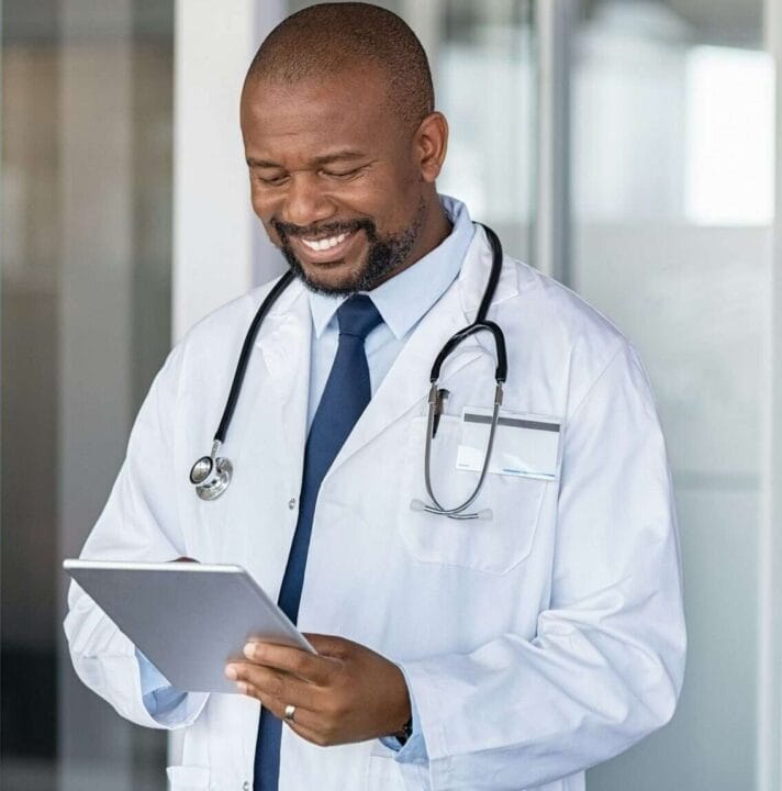 African doctor using digital tablet at hospital