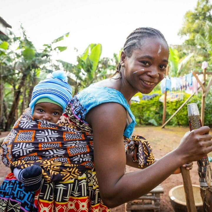 An African mother with her newborn son in the village, African tribal clothing