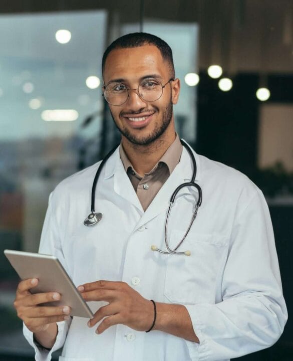 Portrait of happy and successful african american doctor man working inside office clinic holding