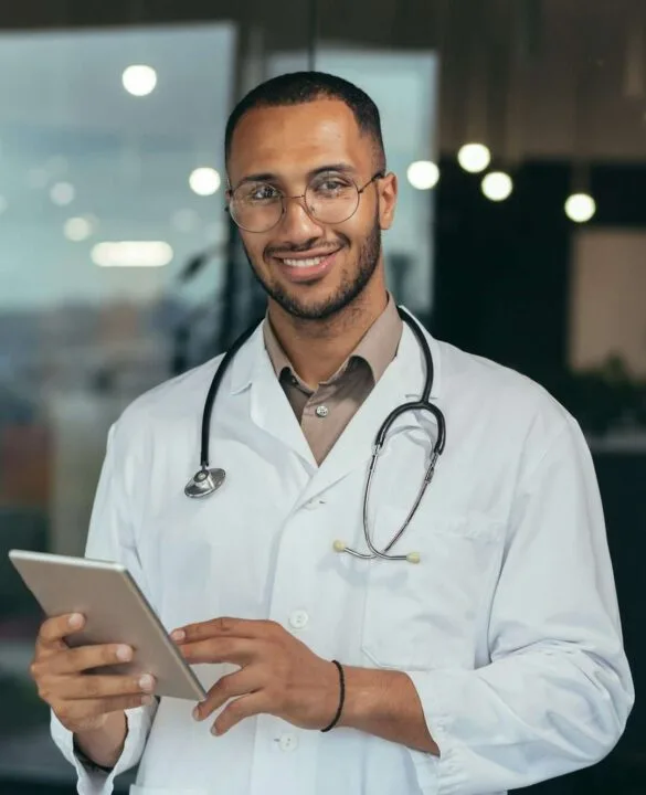 Portrait of happy and successful african american doctor man working inside office clinic holding
